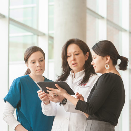 Three women looking at a tablet.